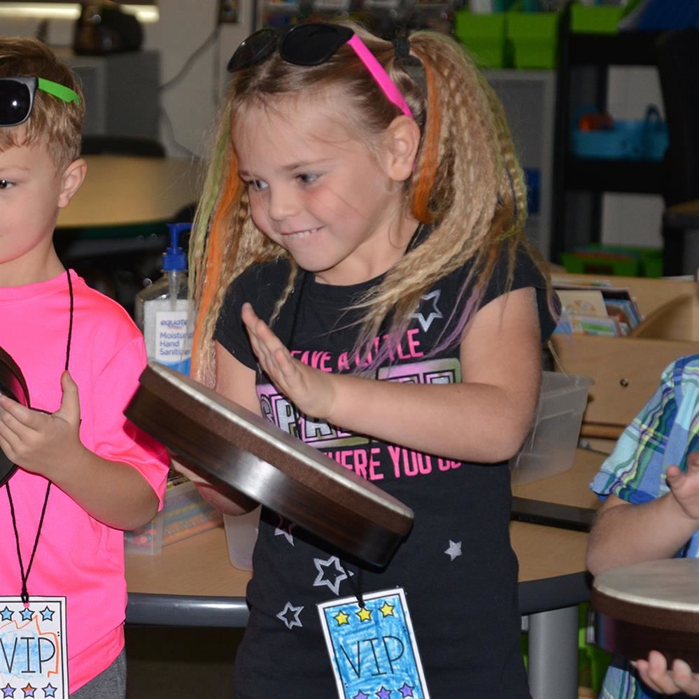  kindergartner girl playing a drum