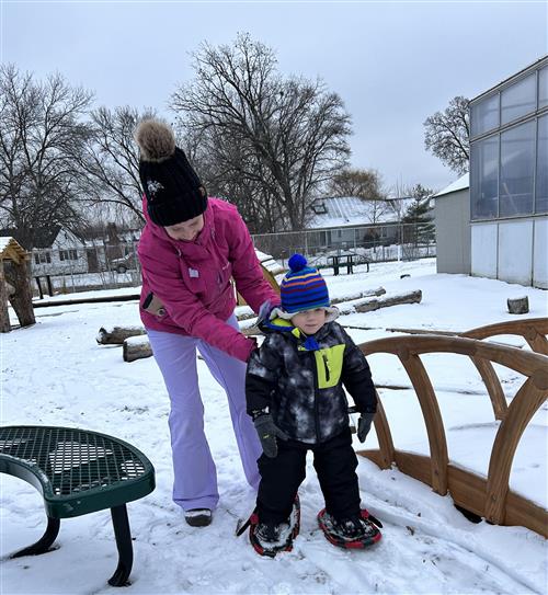 Child and parent outside in snow