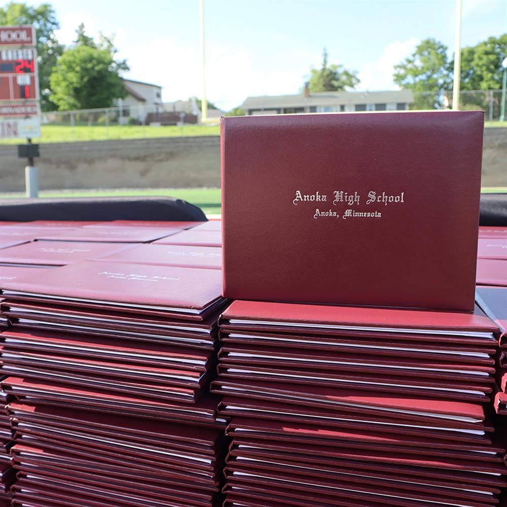  Anoka High School diplomas on a table 