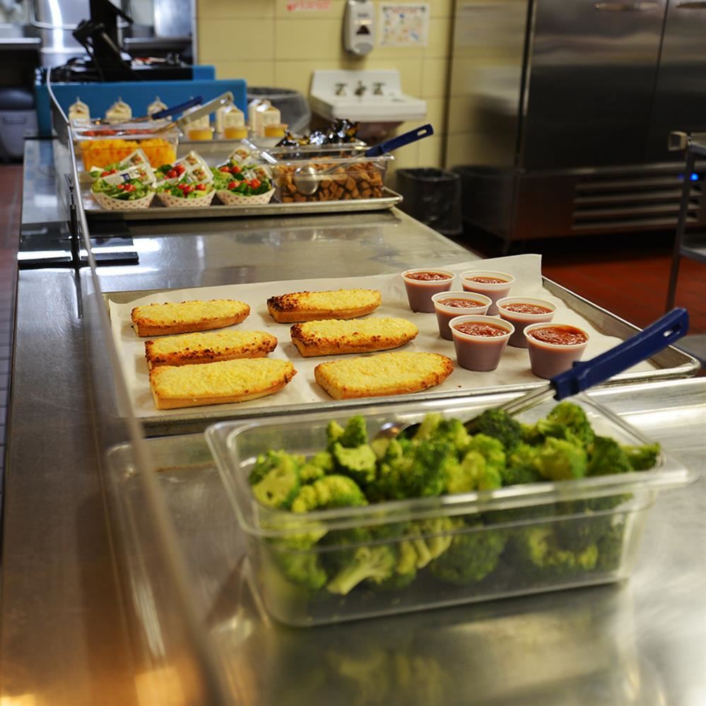 Food displayed in a serving line at an elementary school cafeteria