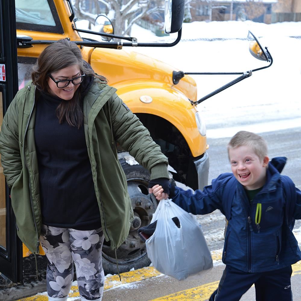  Special Education para with a student near a bus